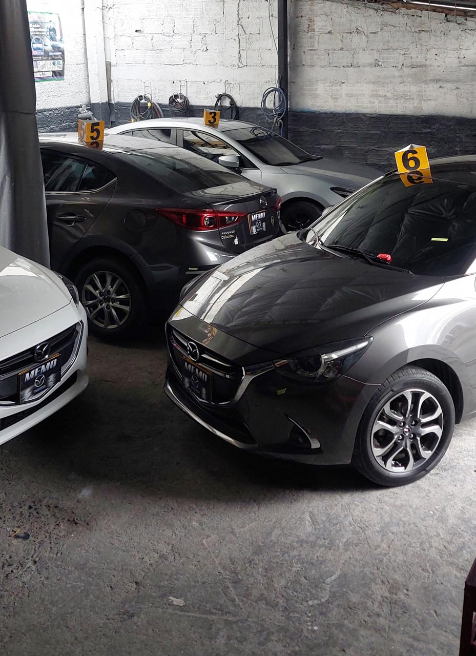 Varios Mazda numerados esperando turno dentro del taller Memo-Mazda