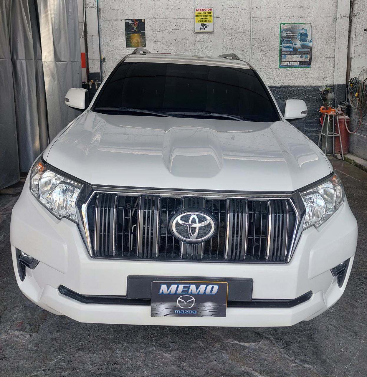 Toyota Prado blanca con el parachoques delantero terminado